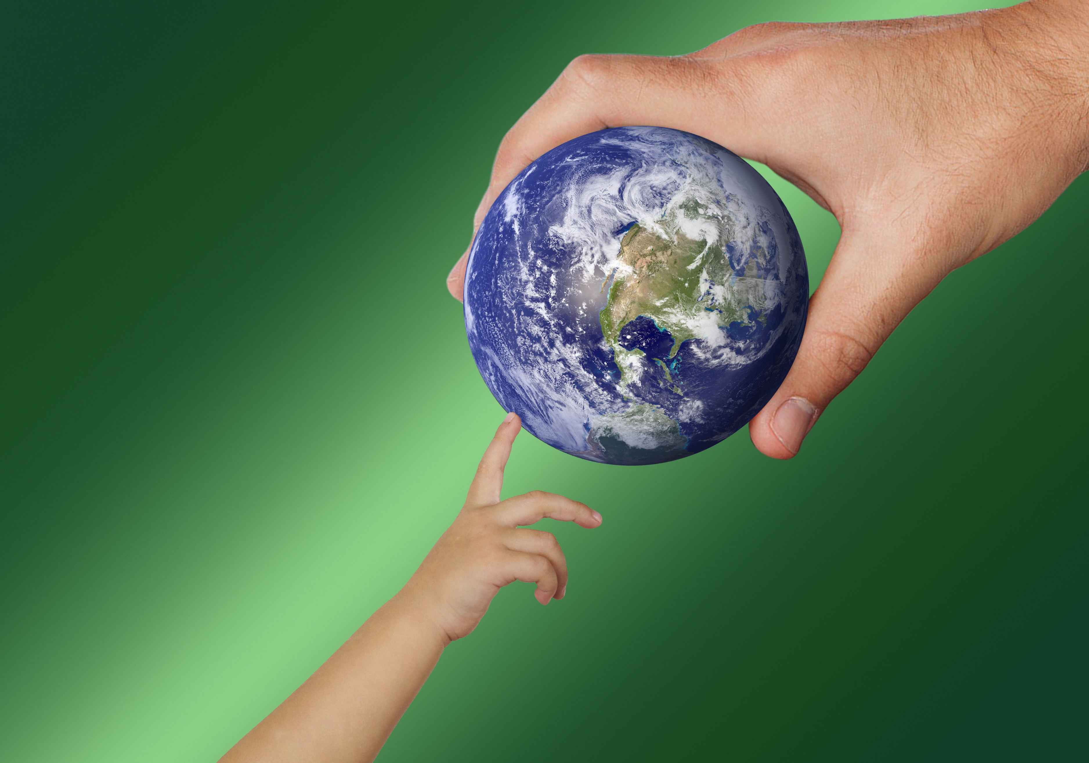 Child touching planet Earth held by an adult