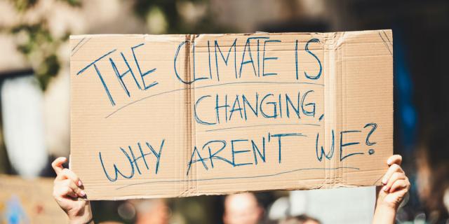 Protest placard quote: "The climate is changing, why aren't we?"